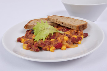 Cowboy beans with bread on a white