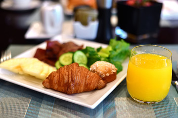 Breakfast from croissant pineapple cucumber and orange juice