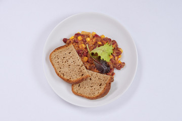 Cowboy beans with bread on a white