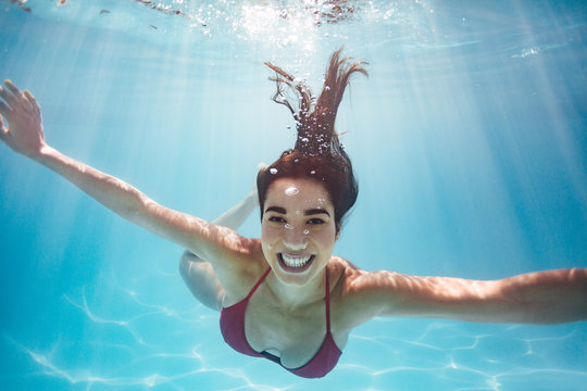 Underwater shot of a smiling woman in pool