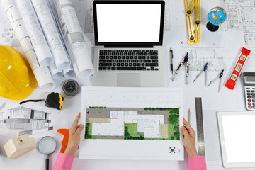 Architect or engineer holding blueprint model engineering equipment on desk at workplace. ...