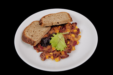 Cowboy beans with bread on a black