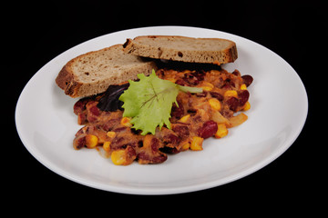 Cowboy beans with bread on a black