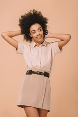 happy young woman in stylish clothes isolated on beige