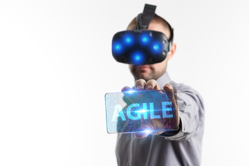 Business, Technology, Internet and network concept. Young businessman working in virtual reality glasses sees the inscription: Agile