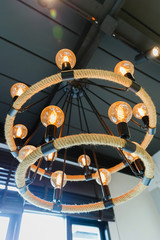 circle orange light bulb, hanging on the ceiling with dark background