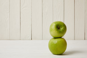 Two raw fresh green apples on wooden background with copy space