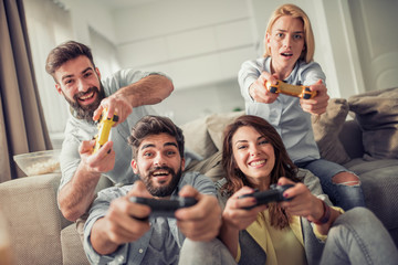 Friends playing video games at home