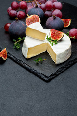 Camembert cheese and cut a slice on stone serving board