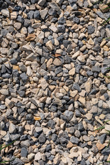 A gravel ground with gravel and stones shining in different shades of grey.