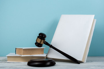 Law concept open book with wooden judges gavel on table in a courtroom or law enforcement office,...