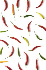 Red, green and yellow hot little chili peppers pattern on white background. Top view. Flat lay.