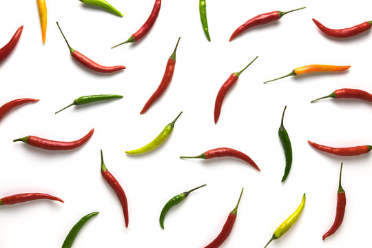 Red, green and yellow hot little chili peppers pattern on white background. Top view. Flat lay.