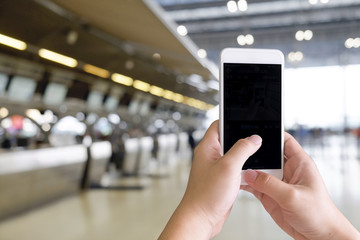 Cropped shot of hands traveler using smartphone mobile in the airport terminal