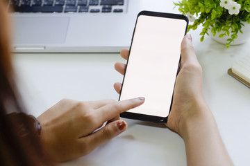 Close up mockup smartphone on hands with white screen display.
