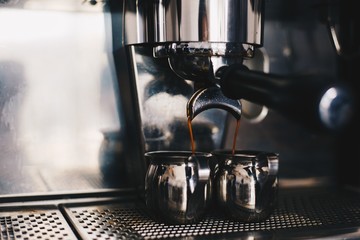 Fototapeta na wymiar Cooking black coffee in the coffee machine close-up