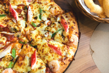 Slice of pizza cheese crust seafood topping sauce. with bell pepper vegetables delicious tasty fast food italian traditional and soft drink carbonated fresh on wooden board table classic.