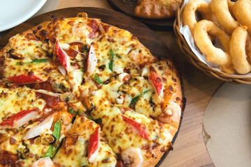 Slice of pizza cheese crust seafood topping sauce. with bell pepper vegetables delicious tasty fast food italian traditional and soft drink carbonated fresh on wooden board table classic.
