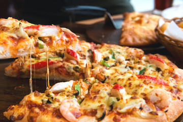 Slice of pizza cheese crust seafood topping sauce. with bell pepper vegetables delicious tasty fast food italian traditional and soft drink carbonated fresh on wooden board table classic.