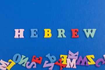 HEBREW word on blue background composed from colorful abc alphabet block wooden letters, copy space for ad text. Learning english concept.