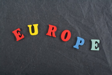 EUROPE word on black board background composed from colorful abc alphabet block wooden letters, copy space for ad text. Learning english concept.