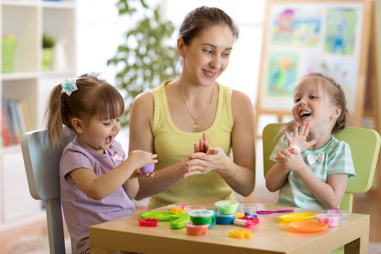 Woman and kids with play clay toys at day care center