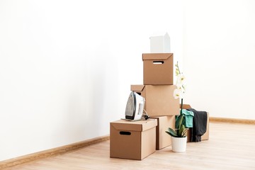 Cardboard boxes with things to move on the floor in an empty room