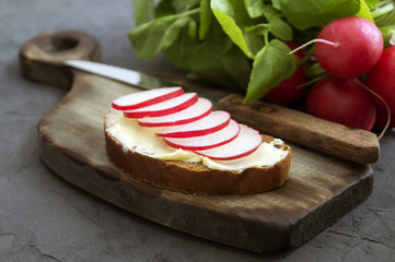 Bread with butter and radish on a wooden Board.