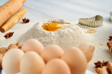 Ingredients for baking cake on the gray table: rolling pin, eggs, spices and bakewares. Baking background. Side view