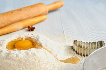 Baking ingredients for dough on the gray table with free copy space: rolling pin, anise stars and bakewares. Baking background. Side view