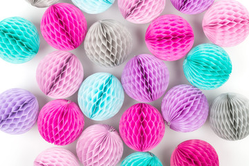 Honeycomb balls decorations background. Pink, lilac and turquoise paper pom pom. Flat lay. Holiday concept