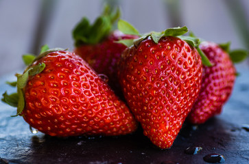 Fresh strawberries on a black slate plate
