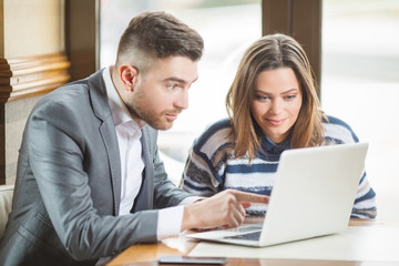 Business couple in cafe working and using laptop