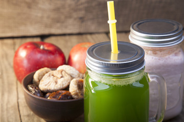 Smoothie in glass jar on rustik wood. Green healthy beverage and fresh fruit