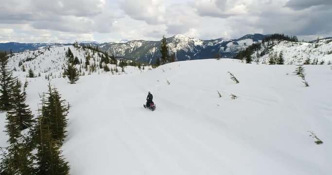 Snowmobile Winter Man Riding Snowmachine Down Mountain Cattrack Aerial View Reveal Nature Background