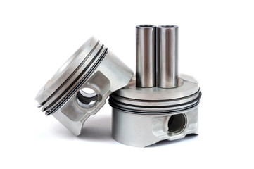 Close-up of spare parts two new pistons with connecting rods for a gasoline engine with installed sets of piston rings on an isolated white background