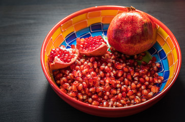 Ripe pomegranate fruit in a jar on wooden vintage background
