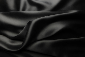 Fototapeta na wymiar Elegant black satin silk with waves, abstract background.