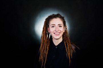 Fototapeta premium Studio shoot of girl in black with dreads at black background with nimbus.