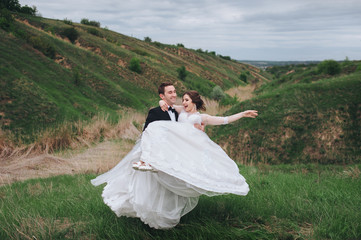 beautiful newlyweds. wedding. the bridegroom is turning round the bride. a great spring day. the bride laughs with pleasure.