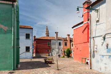Fototapeta na wymiar Small, cozy courtyard with colorful cottage / Burano, Venice/ The small yard with bright walls of houses