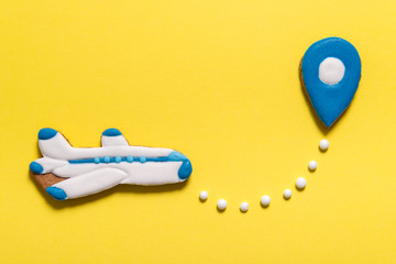 Gingerbread cookies airplane and map point on yellow background