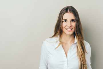 Portrait of young smiling woman in white shirt