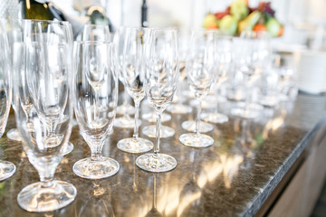 many wineglasses. Breakfast in restaurant of hotel. Plate with fruits and berries on a smorgasbord in the background. Bar