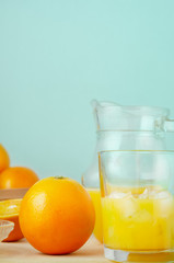 Freshly Squeezed Orange Juice on Wood Table with Aqua Background