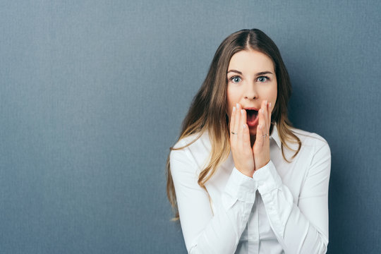 Shocked young woman exclaiming in surprise