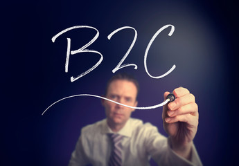 A businessman writing a B2C concept with a white pen on a clear screen.