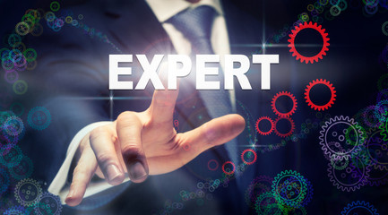 A businessman pressing a Expert business concept on a graphical display of cogs