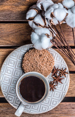 on a wooden background of coffee and kunstku biscuit on a white, a plate of reflux, and next to it lies cotton
