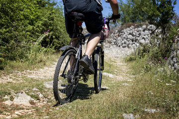 Fototapeta na wymiar Mountain biker ride on a back-country road during Za Sirac Sira, downhill race in Trebinje, Bosnia and Herzegovina.
